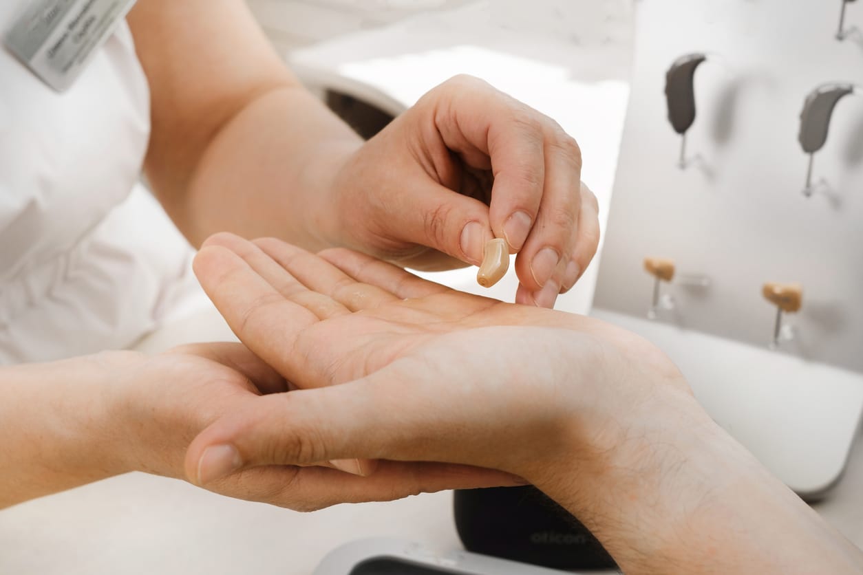 Very small hearing aid in hands