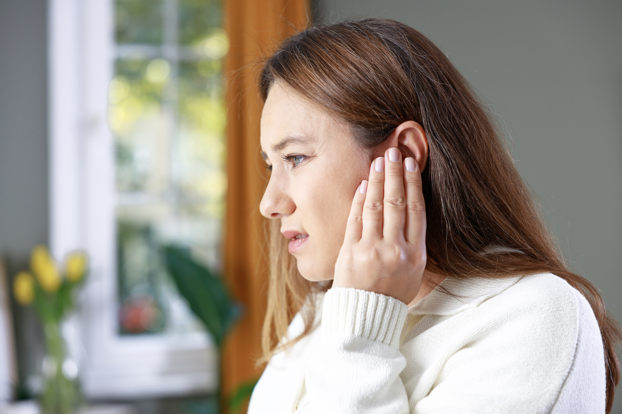 Woman holding her ear