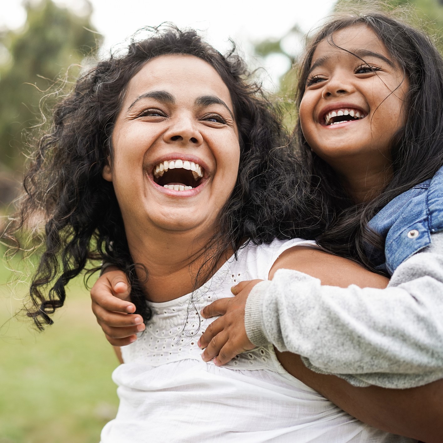 Happy woman and child laughing in a park